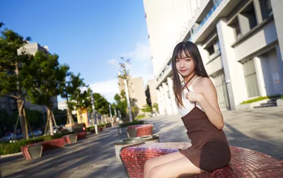 Young Woman Sitting in Modern Urban Plaza - free wallpaper 5177×3261