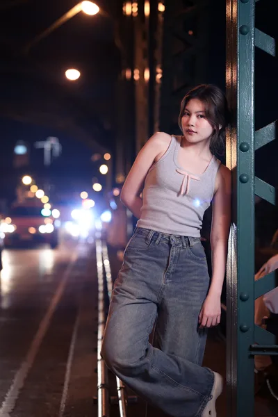 Woman Leaning Against Metal Post on Urban Street at Night - free people & portraits wallpaper 3413×5120