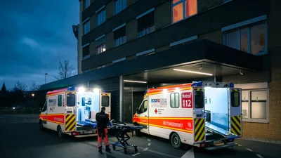 German Emergency Ambulances at Hospital Entrance at Dusk - free cars & vehicles wallpaper 5154×2899