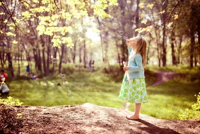 Girl Blowing Bubbles in Sunlit Forest - free wallpaper 4368×2912