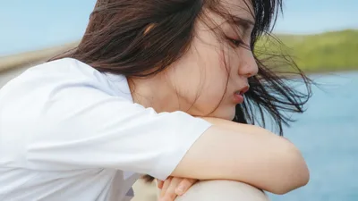 Woman in White Shirt by Water with Wind-Blown Hair - free wallpaper 8520×4792