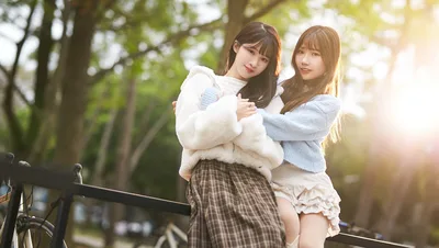 Two Young Women Posing by Railing in Park - free wallpaper 5088×2869