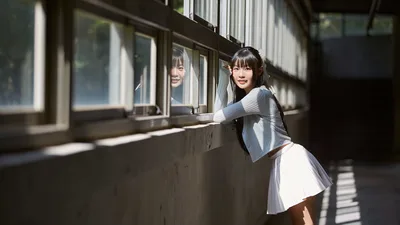 Young Woman Posing by Sunlit Windows in Corridor - free wallpaper 5184×2916