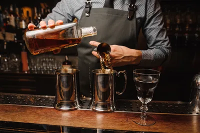 Bartender Pouring Whiskey Into Metal Cups - free wallpaper 4163×2770