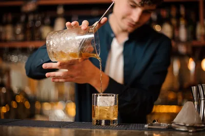 Bartender Pouring Cocktail Into Glass at Bar - free wallpaper 4212×2803