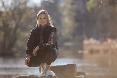 Young Woman Crouching by Riverside in Autumn - free people & portraits wallpaper 5177×3451