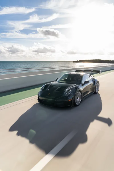 Black Porsche 911 Turbo on Coastal Beach Road - free cars & vehicles wallpaper 6336×9504