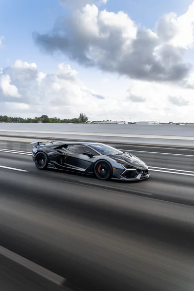 Black Sports Car Racing on Highway Under Cloudy Sky - free cars & vehicles wallpaper 6336×9504
