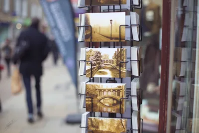 Vintage Postcard Display Stand in Busy Street - free photography wallpaper 8688×5792