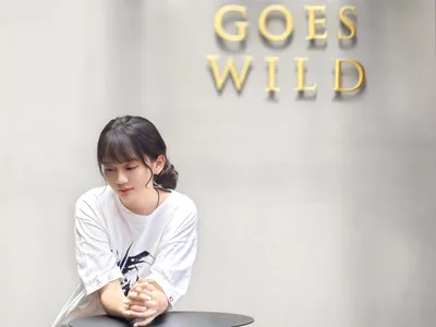 Young Woman in White Shirt Against Wall with Gold Text - free people & portraits wallpaper 3071×2304
