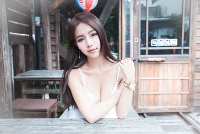 Woman Posing at Outdoor Table in Urban Setting - free wallpaper 5120×3413