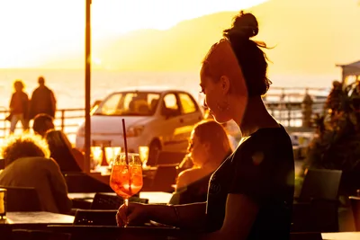 Woman With Sunset Cocktail at Waterfront Gathering - free people & portraits wallpaper 5120×3414