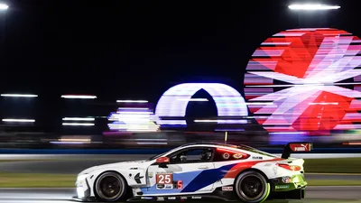 Racing BMW M4 GT3 at Night Under Neon Signage - free cars & vehicles wallpaper 3840×2160