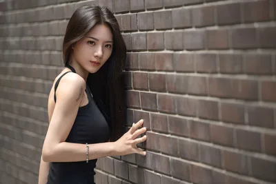 Woman in Black Tank Top Against Brick Wall - free wallpaper 5120×3413