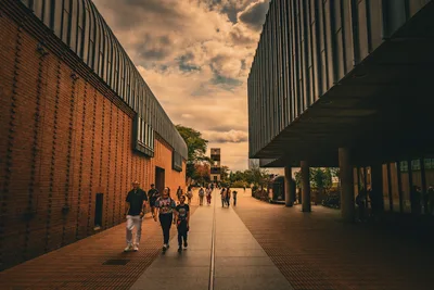 Modern Brick Corridor With People Under Golden Sky - free people & portraits wallpaper 8368×5584