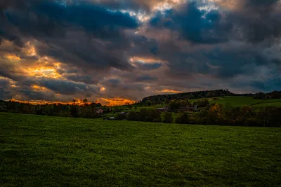 Rolling Green Fields With Farmstead Under Dramatic Sunset - free landscapes wallpaper 7305×4875