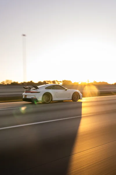White Sports Car Driving at Sunset on Highway - free cars & vehicles wallpaper 6336×9504