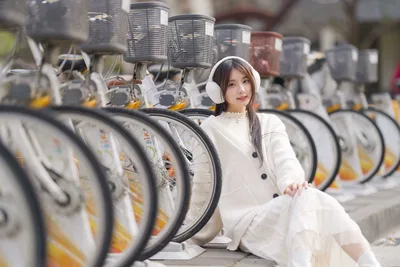 Woman in White Sitting Among Bike-Share Bicycles - free people & portraits wallpaper 5120×3418