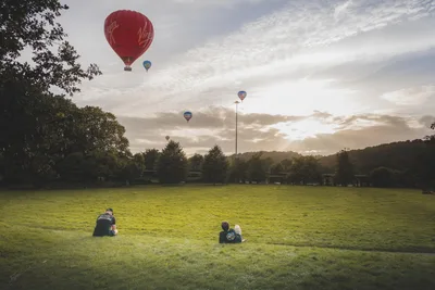 Hot Air Balloons Over Open Field at Sunset - free landscapes wallpaper 8164×5443
