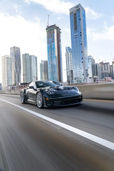 Black Porsche 911 Speeding on Urban Highway with Skyline - free cars & vehicles wallpaper 6336×9504
