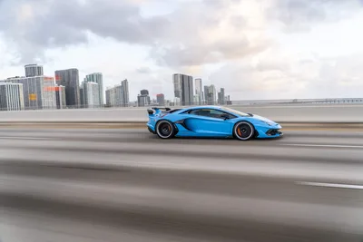 Blue Sports Car on Bridge with City Skyline - free cars & vehicles wallpaper 9504×6336