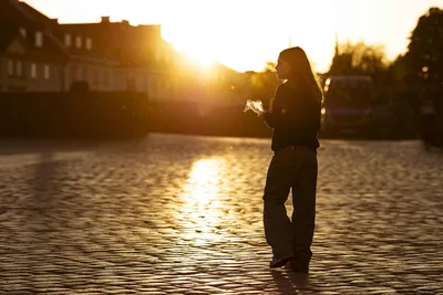 Woman Standing in Sunlit Square at Golden Hour - free people & portraits wallpaper 5776×3851