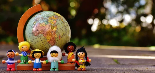 Diverse Wooden Dolls with Vintage Globe in Garden Setting - free photography wallpaper 5648×2679