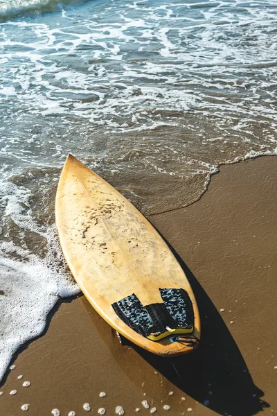 Golden Surfboard Meets Ocean Waves at Sandy Shore - free dark wallpaper 800×1200