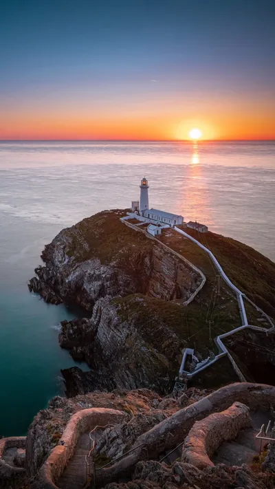 Lighthouse Sunrise Over Rocky Shores - free wallpaper 1152×2048