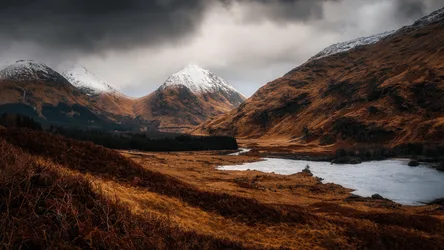 Glencoe's Snowy Peaks Under Brooding Skies - free wallpaper 5120×2880