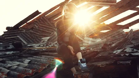 Woman Among Rusted Industrial Beams at Sunset - free wallpaper 5120×2880