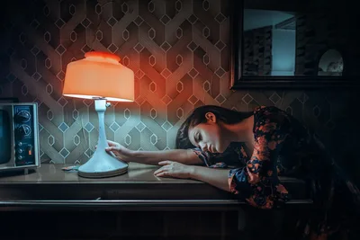 Woman at Desk Under Glowing Orange Lamp in Retro Room - free wallpaper 2048×1366