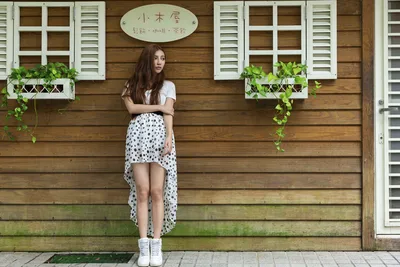Woman in Polka Dot Skirt Against Wooden Building - free wallpaper 5120×3413