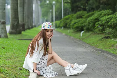 Young Girl Posing on Garden Pathway with Floral Cap - free wallpaper 5120×3413
