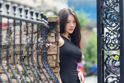 Woman in Black Top Poses by Ornate Gate - free wallpaper 5120×3413