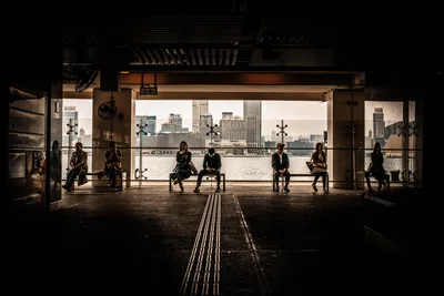 Silhouetted Figures in Waterfront Terminal with City View - free people & portraits wallpaper 5976×3992