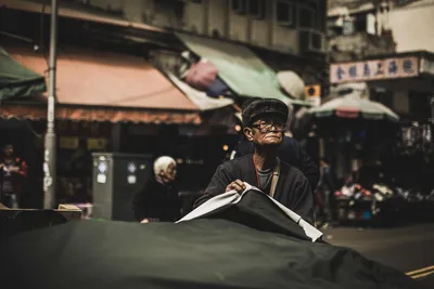 Elderly Man Reading Newspaper in Asian Street Market - free people & portraits wallpaper 5120×3413