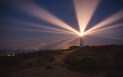 Lighthouse Beam Piercing Night Sky with Stars - free landscapes wallpaper 6144×3840