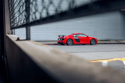 Red Sports Car Parked Against Industrial Metal Wall - free wallpaper 6720×4480