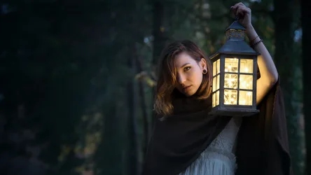 Woman Holding Glowing Lantern in Dark Forest - free wallpaper 3840×2160