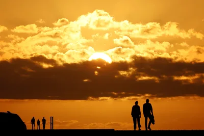 Silhouetted Figures Against Golden Sunset Sky - free wallpaper 3072×2048