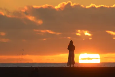 Silhouetted Figure Standing Before Sunset Over Ocean - free wallpaper 3762×2508