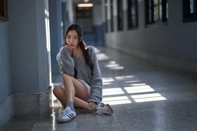 Young Woman Crouching in Modern Hallway with Sunlight - free people & portraits wallpaper 3000×1992