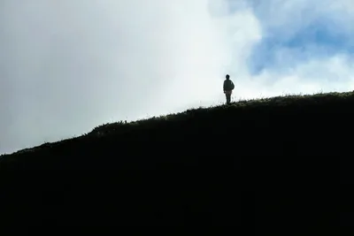Solitary Hiker Standing on Grassy Hillside - free nature wallpaper 5472×3648