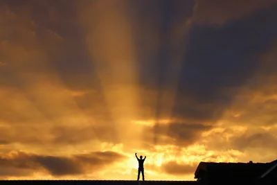 Silhouetted Figure with Arms Raised at Sunset - free nature wallpaper 6144×4096
