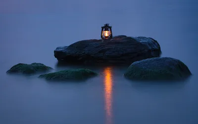 Lantern on Rocky Outcrop Over Misty Ocean at Dusk - free nature wallpaper 5818×3636