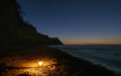 Lantern on Rocky Beach at Twilight with Cliff - free wallpaper 5917×3698