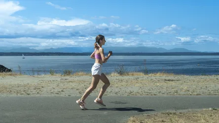 Woman Jogging on Lakeside Road with Mountain View - free people & portraits wallpaper 4096×2304