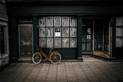 Orange Bicycle Outside Dark Storefront with Art Display - free city & urban wallpaper 5976×3992