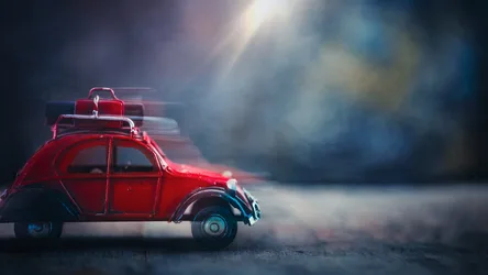 Red Vintage Toy Car With Luggage on Moody Background - free wallpaper 5692×3202